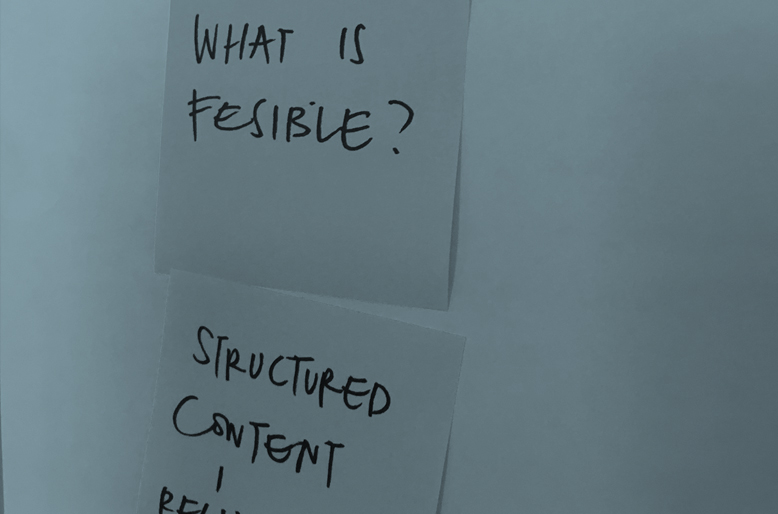 Post-it on whiteboard with words 'what is feasible' and 'structured content' visible